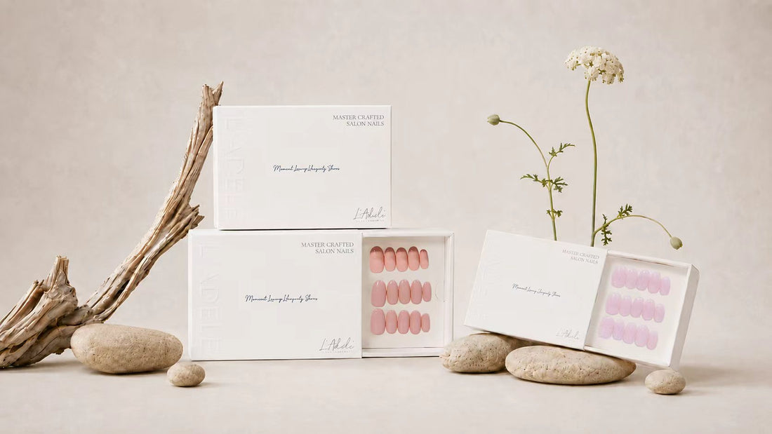 Drei Schachteln handgefertigte Press-on Nails von L'Adele in Rosa und Lila, mit Treibholz und einer Blüte