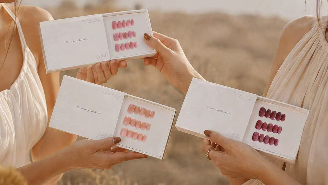 Zwei Frauen halten drei Schachteln handgefertigte Press-on Nails von L'Adele